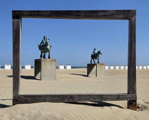 a mirror frame with two statues of horses on the beach at Moon Lodge in Koksijde