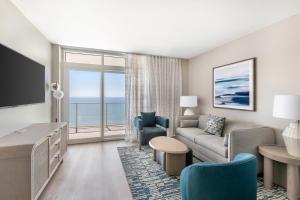 a living room with a couch and a tv at Hilton Grand Vacations Club Ocean 22 Myrtle Beach in Myrtle Beach