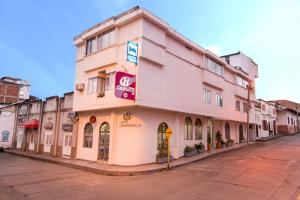 um edifício cor-de-rosa ao lado de uma rua em Casablanca Hotel, RestoBar, Catering, Eventos & Turismo en Garzón em Garzón