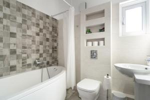 a bathroom with a tub and a toilet and a sink at Nirvana Homes in Vlachata +42 photos