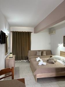 ein Wohnzimmer mit zwei Betten und einem Fernseher in der Unterkunft STUDIO ZOE in Marmari