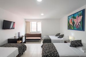 a hotel room with two beds and a couch at Casablanca Hotel, RestoBar, Catering, Eventos & Turismo en Garzón in Garzón +39 photos