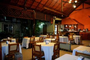 a restaurant with white tables and chairs and a bar at Hotel Europeo in Managua