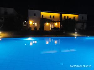 a swimming pool in front of a house at night at Villa Kadrina in Kolymbia +28 photos
