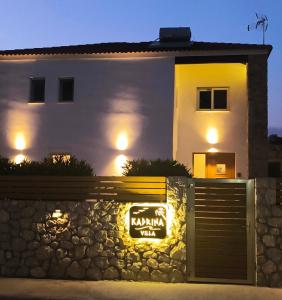a house with a sign in front of a wall at Villa Kadrina in Kolymbia