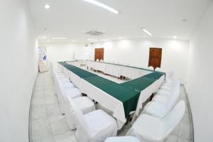 a conference room with white chairs and a green table at Hotel Europeo in Managua +120 photos