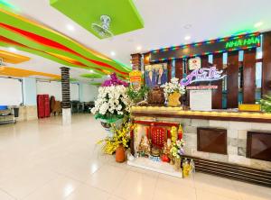 a lobby with a counter with flowers on it at Palette Anh Vu Hotel Phu Quoc in Phú Quốc