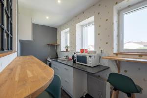 a small kitchen with a table and a microwave at Les Brimbelles in Brû