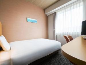 a hotel room with a bed and a desk and a window at Comfort Hotel Gifu in Gifu