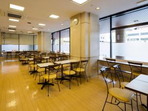 a dining room with tables and chairs and a clock at Comfort Hotel Sakai in Sakai
