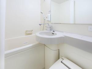 a white bathroom with a sink and a mirror at Comfort Hotel Koriyama in Koriyama +26 photos
