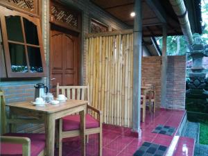 Habitación con mesa, sillas y puerta en Tara House en Ubud