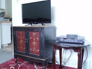 a tv on top of a wooden cabinet with a table at Cozy Cottage in Canora +7 photos