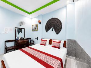 a bedroom with a white bed and a desk at Palette Anh Vu Hotel Phu Quoc in Phú Quốc