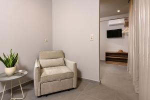 a living room with a chair and a table at Aeliana Thassos Studios & Lofts in Skala Rachoniou