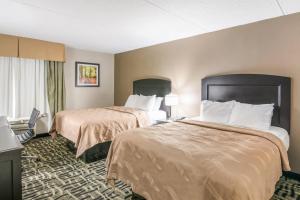 a hotel room with two beds and a window at Quality Inn Rochester West in Rochester