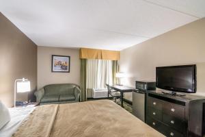 a hotel room with a bed and a flat screen tv at Quality Inn Rochester West in Rochester