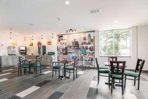 a dining room with tables and chairs and a kitchen at Quality Inn Rochester West in Rochester