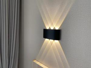a light on a wall with a curtain at AiRom Hotel in Atyrau