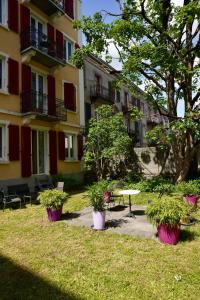 a building with a table and potted plants in a yard at Heure Cosy in La Chaux-de-Fonds