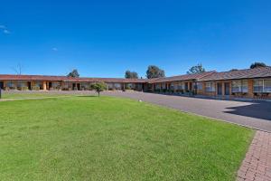 a building with a green lawn in front of it at Econo Lodge Savannah Park Tamworth in Tamworth