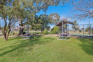 a park with two picnic tables in the grass at Econo Lodge Savannah Park Tamworth in Tamworth