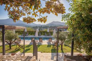 a view of a pool with chairs and umbrellas at Marcora Historic Mansion in Strongylí