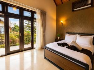 a bedroom with a bed and a large window at The Manor Hanthana in Kandy