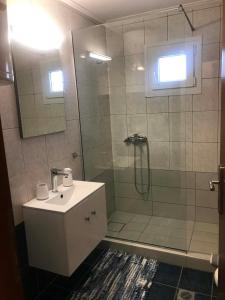 a bathroom with a shower and a sink and a mirror at Stasa Luxury Apartments in Keramoti +46 photos