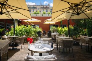 a patio with tables and chairs with umbrellas at DoubleTree by Hilton Paris Boulogne in Boulogne-Billancourt
