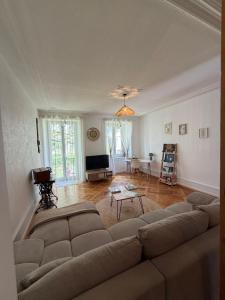 a living room with a couch and a television at Heure Cosy in La Chaux-de-Fonds