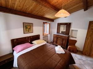 a bedroom with a large bed and a wooden ceiling at Chalet Amandola in Moglietta