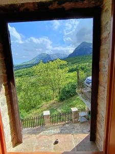 a window with a view of a field and mountains at Chalet Amandola in Moglietta