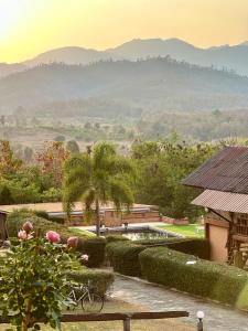 a garden with a pool and a view of mountains at Paihappy village in Ban Thung Pong