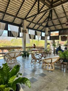a restaurant with tables and chairs and people in the background at Paihappy village in Ban Thung Pong