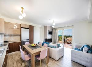 a kitchen and living room with a table and chairs at Cataleya - Sea & Sunset View Apartment in Tsoukalades +20 photos