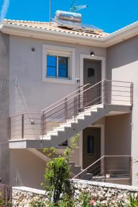 a house with a staircase in front of it at Cataleya - Sea & Sunset View Apartment in Tsoukalades