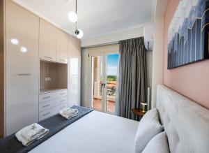 a bedroom with a white bed and a window at Cataleya - Sea & Sunset View Apartment in Tsoukalades
