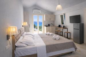 ein Schlafzimmer mit einem großen Bett, auf dem Handtücher liegen in der Unterkunft Theta Project in Stavros