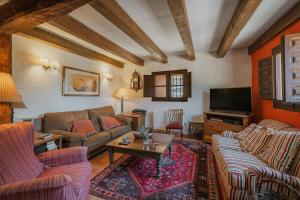 a living room with a couch and a tv at Casa La Romana in Ayllón