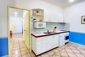 
a kitchen with a microwave and a sink at Habitat Resort in Broome
