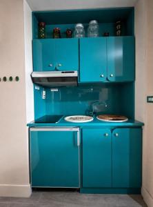 a blue kitchen with a stove and blue cabinets at ComeCasa La Magdeleine 2BDR APT in La Magdeleine