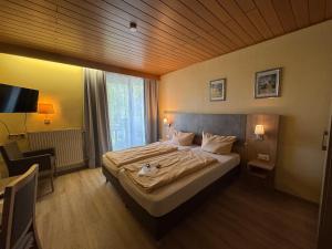 a bedroom with a large bed with a wooden ceiling at Hotel am Rosenbad in Fulda