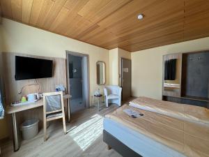 a bedroom with a bed and a desk and a tv at Hotel am Rosenbad in Fulda +16 photos