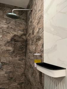 a bathroom with a stone wall at Kalih Homestay Bali in Kuta