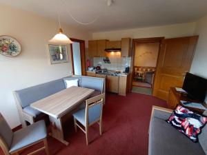 a living room with a table and a kitchen at Landhaus Rieder in Mittersill