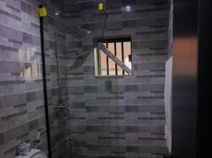 a bathroom with a shower with a toilet and a window at Maxbliss Optimum Royal Hotel in Benin City