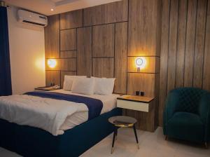a hotel room with a bed and a chair at Maxbliss Optimum Royal Hotel in Benin City