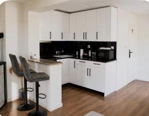 a kitchen with white cabinets and a bar stool at Holiday home Damian - Private pool in Ðurđekovec