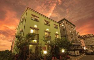 a green building next to a building with a cloudy sky at Chorok Pension in Boryeong